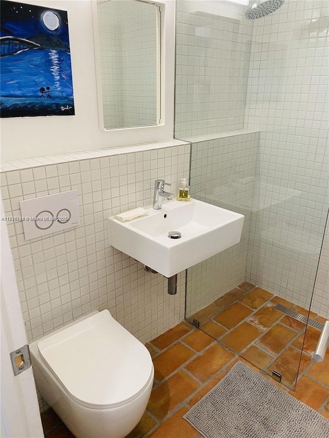 bathroom with sink, tile walls, and toilet