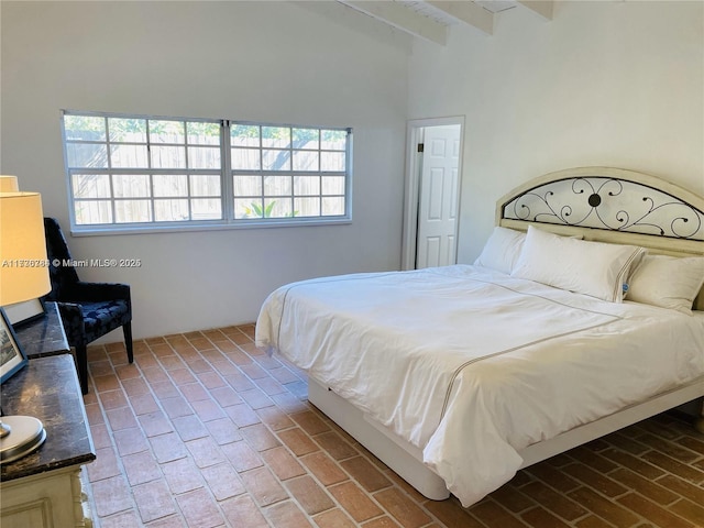 bedroom with vaulted ceiling with beams