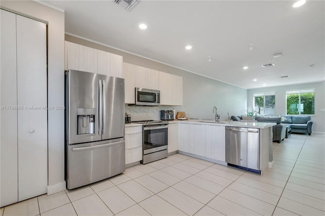 kitchen featuring light tile patterned flooring, sink, backsplash, kitchen peninsula, and stainless steel appliances