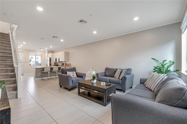 living room with crown molding and light tile patterned floors