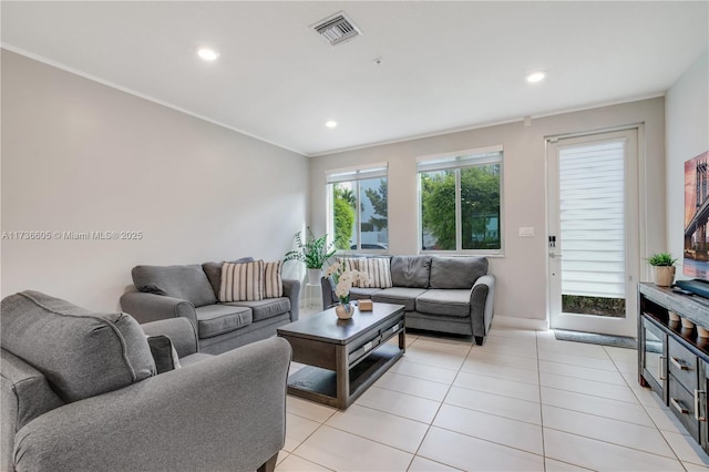 living room with light tile patterned floors and crown molding