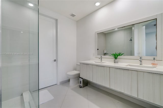 bathroom with vanity, walk in shower, tile patterned floors, and toilet