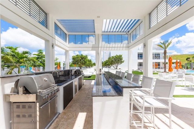 view of patio featuring a grill, exterior kitchen, and a wet bar