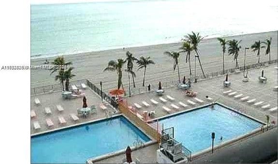 community pool featuring a water view and a patio area
