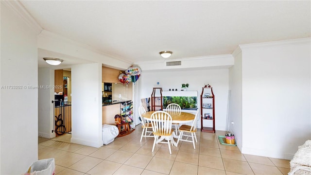 dining room with ornamental molding and light tile patterned flooring