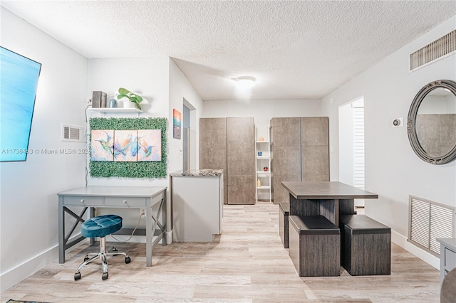 office space featuring light hardwood / wood-style flooring and a textured ceiling