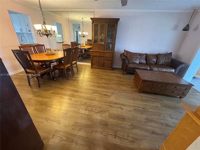 dining space with a notable chandelier, wood-type flooring, and ornamental molding