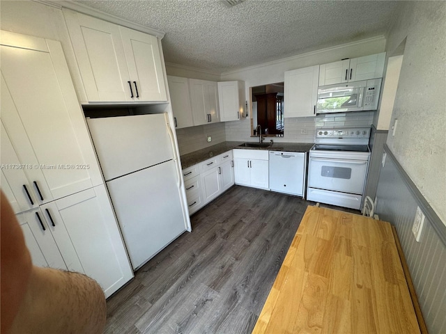 kitchen with white cabinetry, butcher block counters, sink, and white appliances