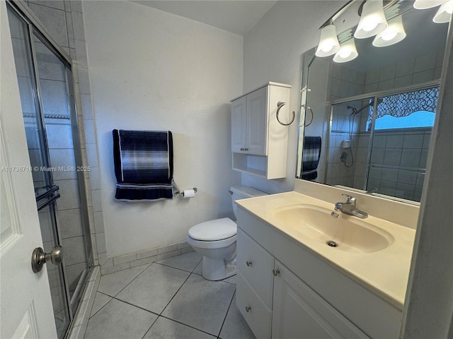 bathroom featuring tile patterned flooring, vanity, a shower with shower door, and toilet