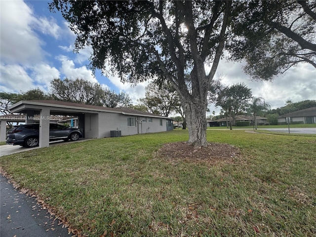 exterior space with cooling unit, a carport, and a front yard