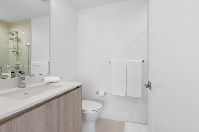 bathroom with tile patterned flooring, vanity, walk in shower, and toilet