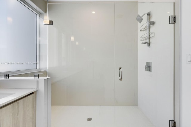 bathroom with a shower with door and vanity