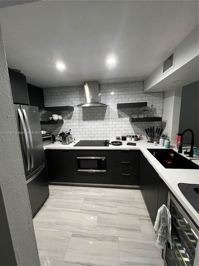 kitchen with sink, stainless steel refrigerator, black electric stovetop, oven, and wall chimney range hood