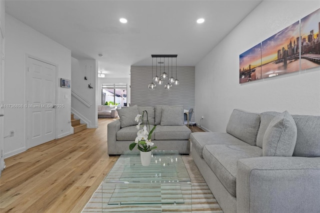 living room featuring a chandelier and light wood-type flooring