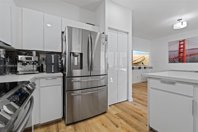 kitchen featuring appliances with stainless steel finishes, white cabinets, and light wood-type flooring