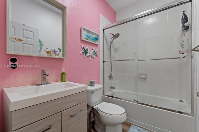 full bathroom featuring vanity, toilet, and combined bath / shower with glass door