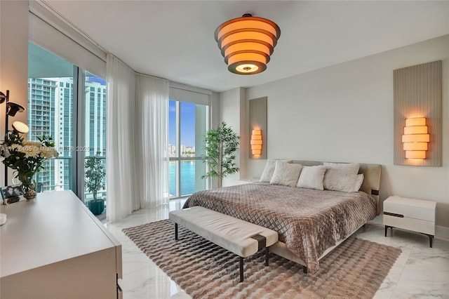 bedroom with access to exterior, floor to ceiling windows, and a water view