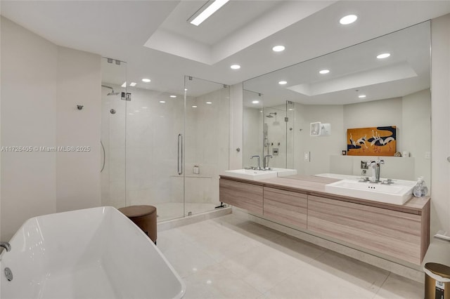 bathroom featuring independent shower and bath, vanity, and a tray ceiling