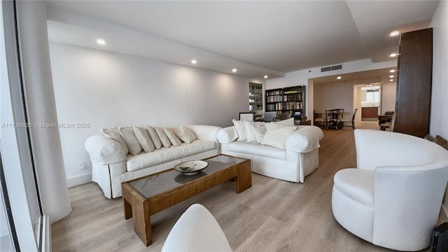 living area with light wood finished floors, visible vents, and recessed lighting