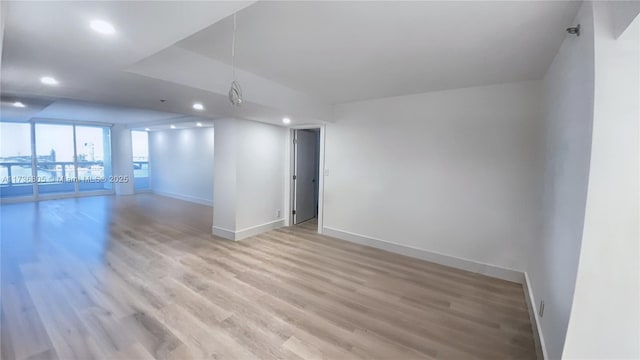 spare room with light wood-style flooring, baseboards, and recessed lighting