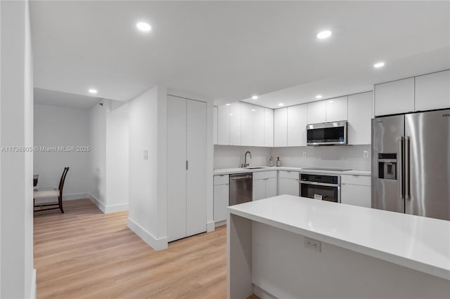 1717 N Bayshore Dr Unit A-1231, Miami, FL 33132 - kitchen with stainless steel appliances, modern cabinets, light wood-style floors, light countertops, and white cabinets