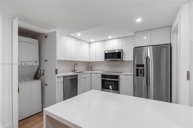 1717 N Bayshore Dr Unit A-1231, Miami, FL 33132 - kitchen featuring appliances with stainless steel finishes, stacked washer / dryer, modern cabinets, white cabinetry, and recessed lighting