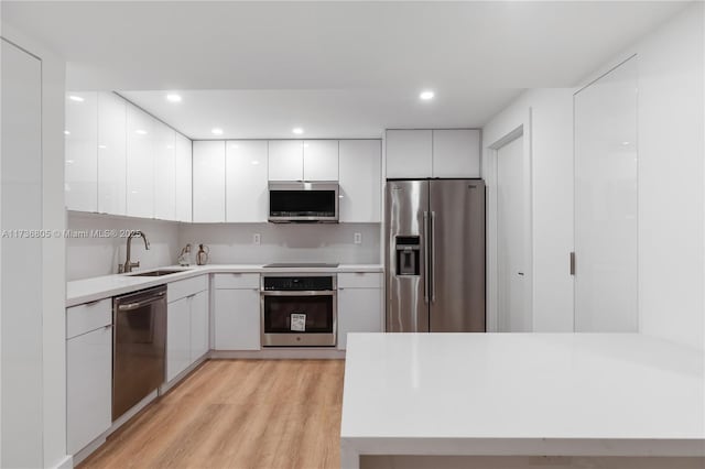 1717 N Bayshore Dr Unit A-1231, Miami, FL 33132 - kitchen with stainless steel appliances, modern cabinets, white cabinets, light countertops, and light wood finished floors