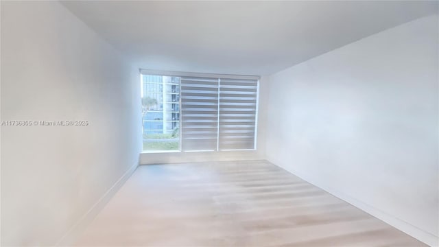 unfurnished room with baseboards and wood finished floors