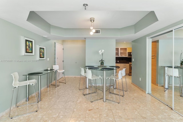 dining room featuring a raised ceiling