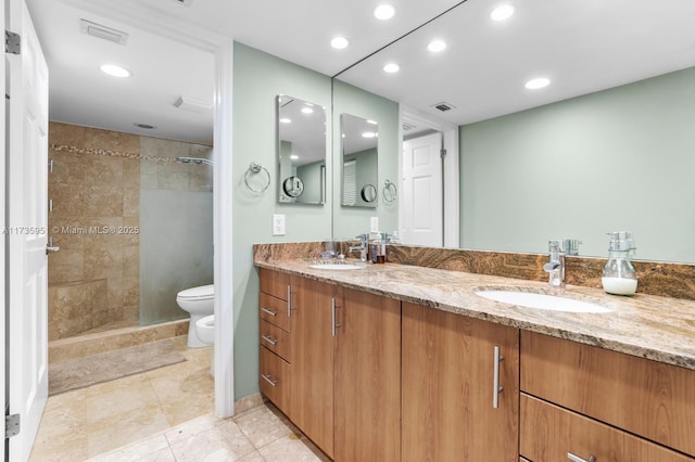 bathroom featuring a bidet, tile patterned flooring, vanity, a tile shower, and toilet