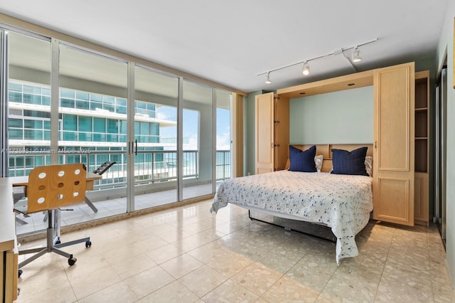 bedroom featuring access to exterior, light tile patterned floors, and expansive windows