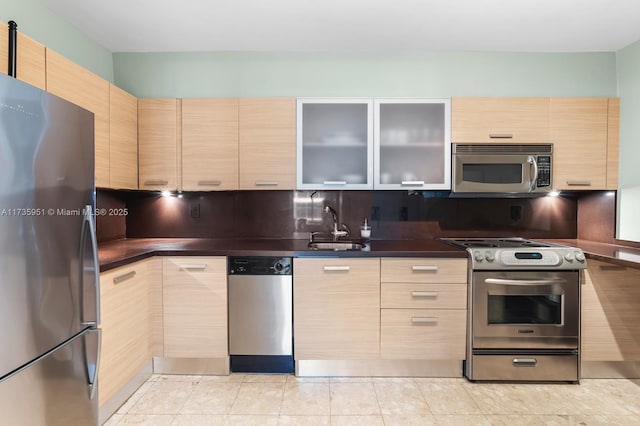 kitchen featuring sink, backsplash, stainless steel appliances, light tile patterned flooring, and light brown cabinetry