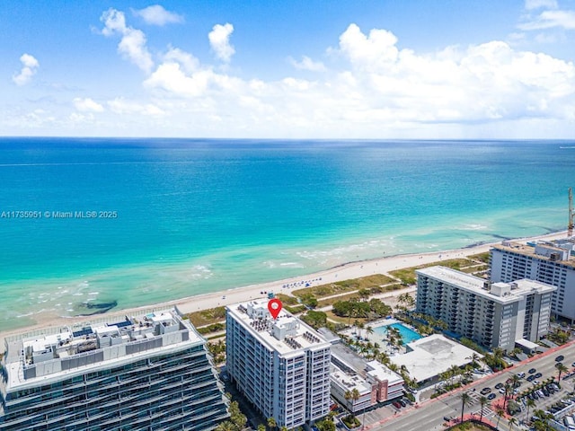 birds eye view of property with a water view and a beach view