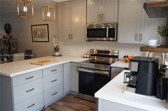 kitchen featuring appliances with stainless steel finishes, decorative light fixtures, gray cabinetry, and light stone countertops