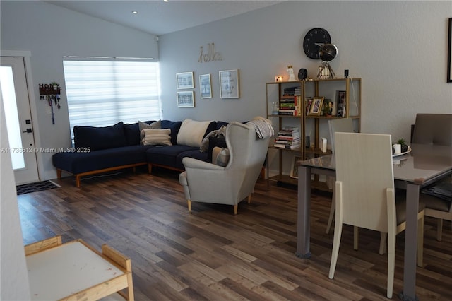 living room featuring dark wood-type flooring and vaulted ceiling