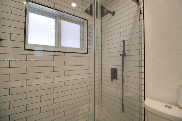 full bathroom featuring a stall shower and toilet