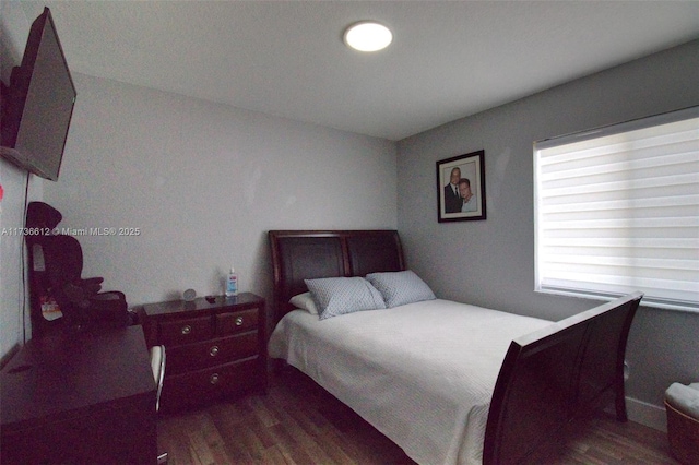 bedroom with dark wood-style flooring