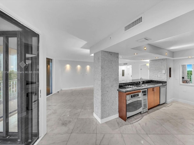 kitchen with appliances with stainless steel finishes, beverage cooler, and sink