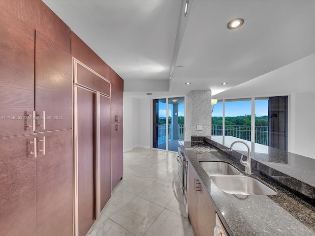 kitchen featuring dark stone counters, sink, and gas stovetop