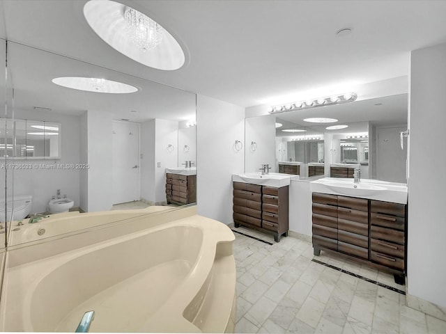 bathroom with a bidet, vanity, and a bathtub