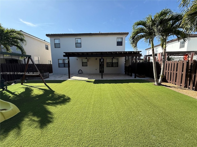 rear view of house featuring a pergola, a patio area, and a lawn