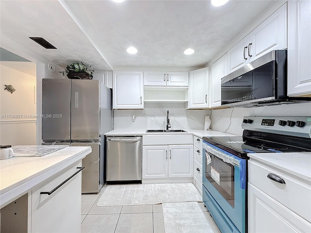 kitchen featuring tasteful backsplash, sink, white cabinets, and appliances with stainless steel finishes