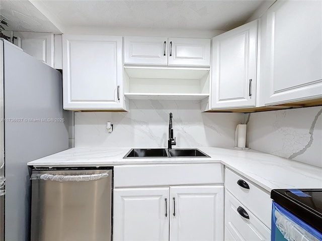 kitchen featuring tasteful backsplash, dishwasher, sink, white cabinets, and light stone counters