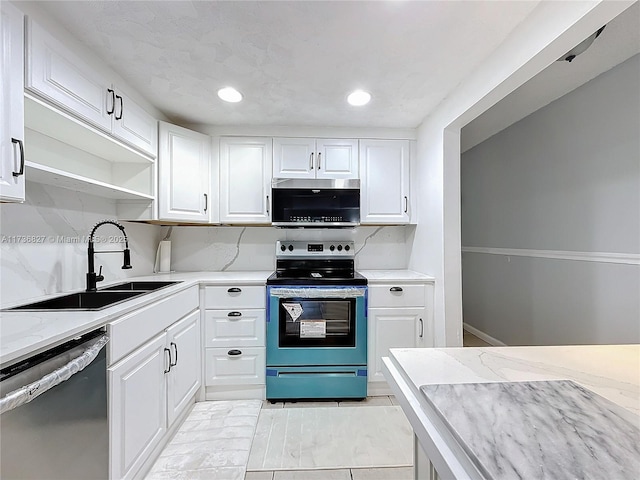 kitchen with appliances with stainless steel finishes, sink, white cabinets, and backsplash