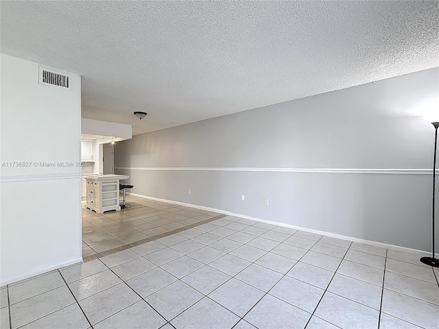 unfurnished living room with light tile patterned floors and a textured ceiling