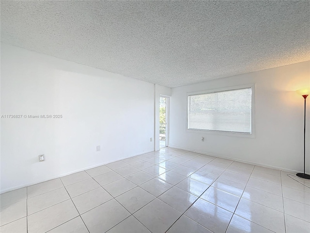 tiled spare room with a textured ceiling