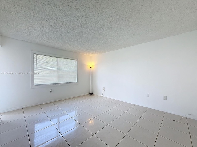 unfurnished room with light tile patterned flooring and a textured ceiling