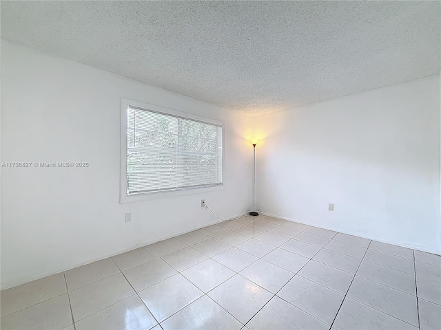 tiled spare room with a textured ceiling