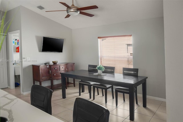 dining space with a ceiling fan, visible vents, vaulted ceiling, and baseboards