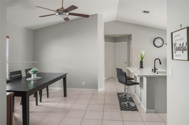 dining area featuring light tile patterned floors, lofted ceiling, visible vents, baseboards, and a ceiling fan